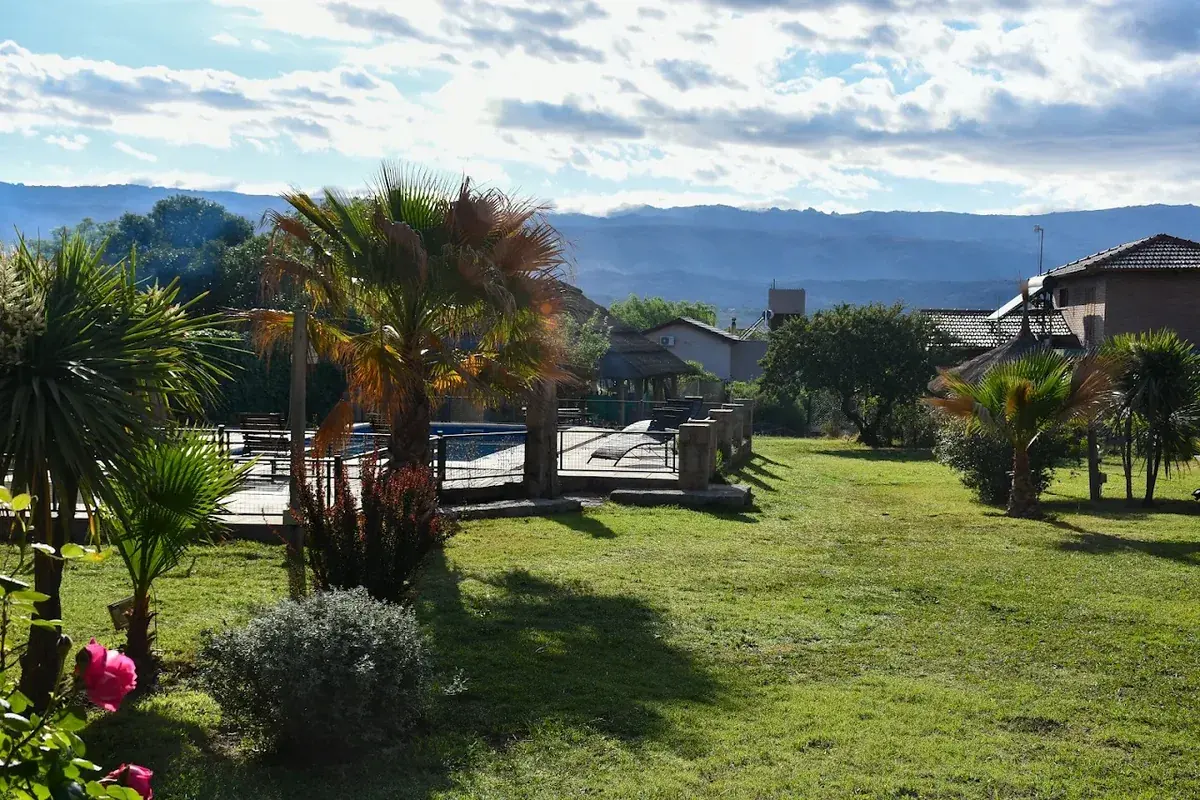El parque del complejo, con palmeras y las sierras de fondo